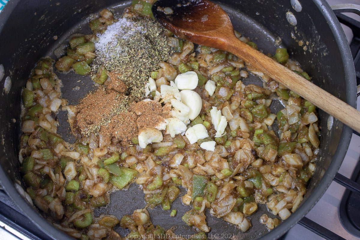 garlic and herbs and spices added to the triity cooked in a roux in a Dutch oven