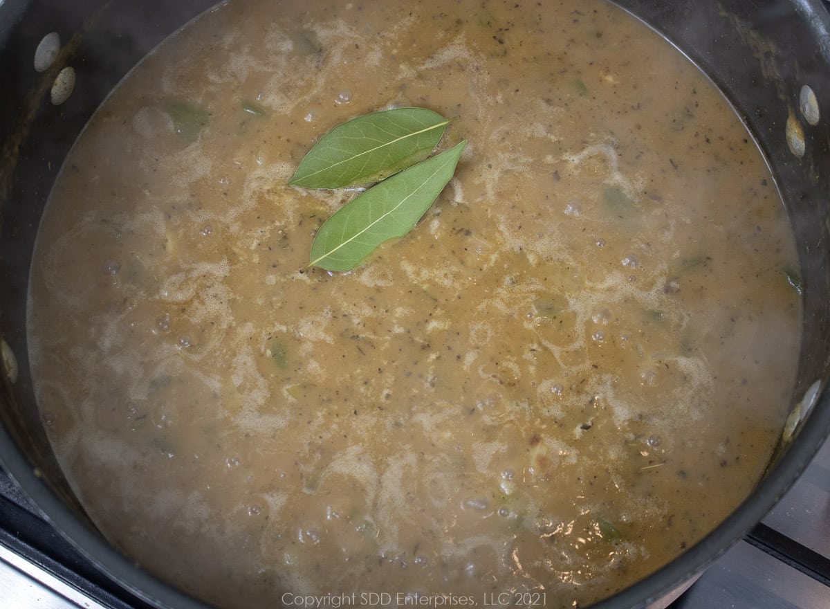 bay leaves in a gravy simmering in a Dutch oven