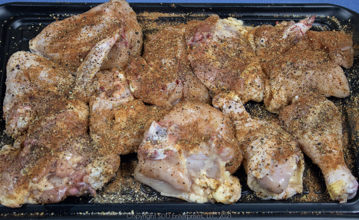 cut up, seasoned chicken on a prep board