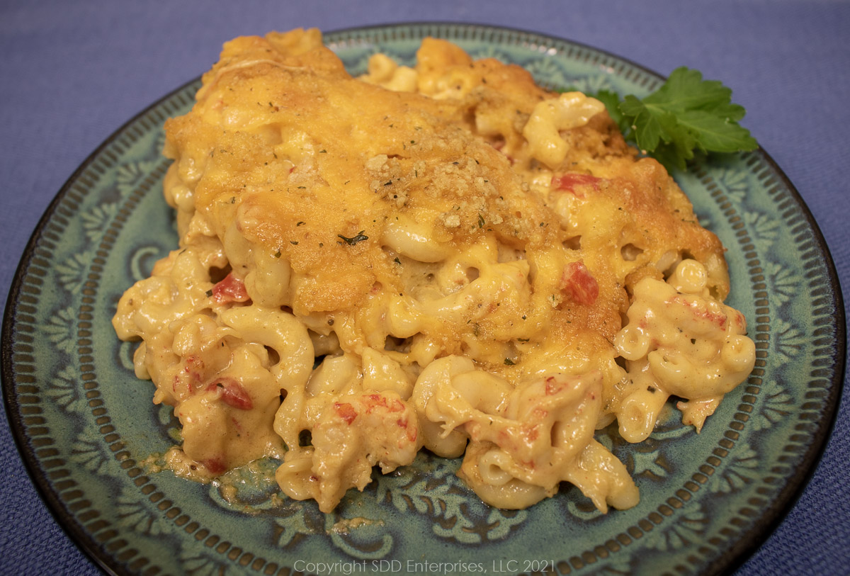 Crawfish mac and cheese on a green plate with parsley garnish.