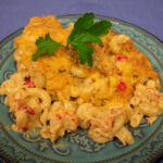 crawfish mac and cheese on a green plate with parsley garnish