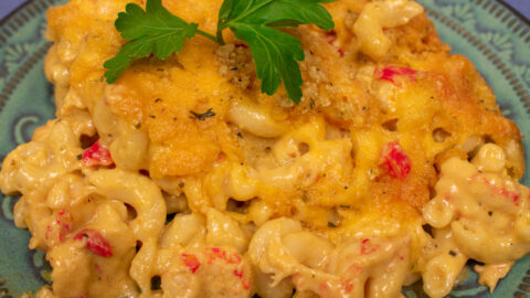 crawfish mac and cheese on a green plate with parsley garnish