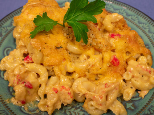 crawfish mac and cheese on a green plate with parsley garnish