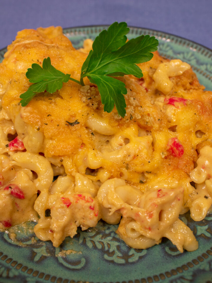 crawfish mac and cheese on a green plate with parsley garnish