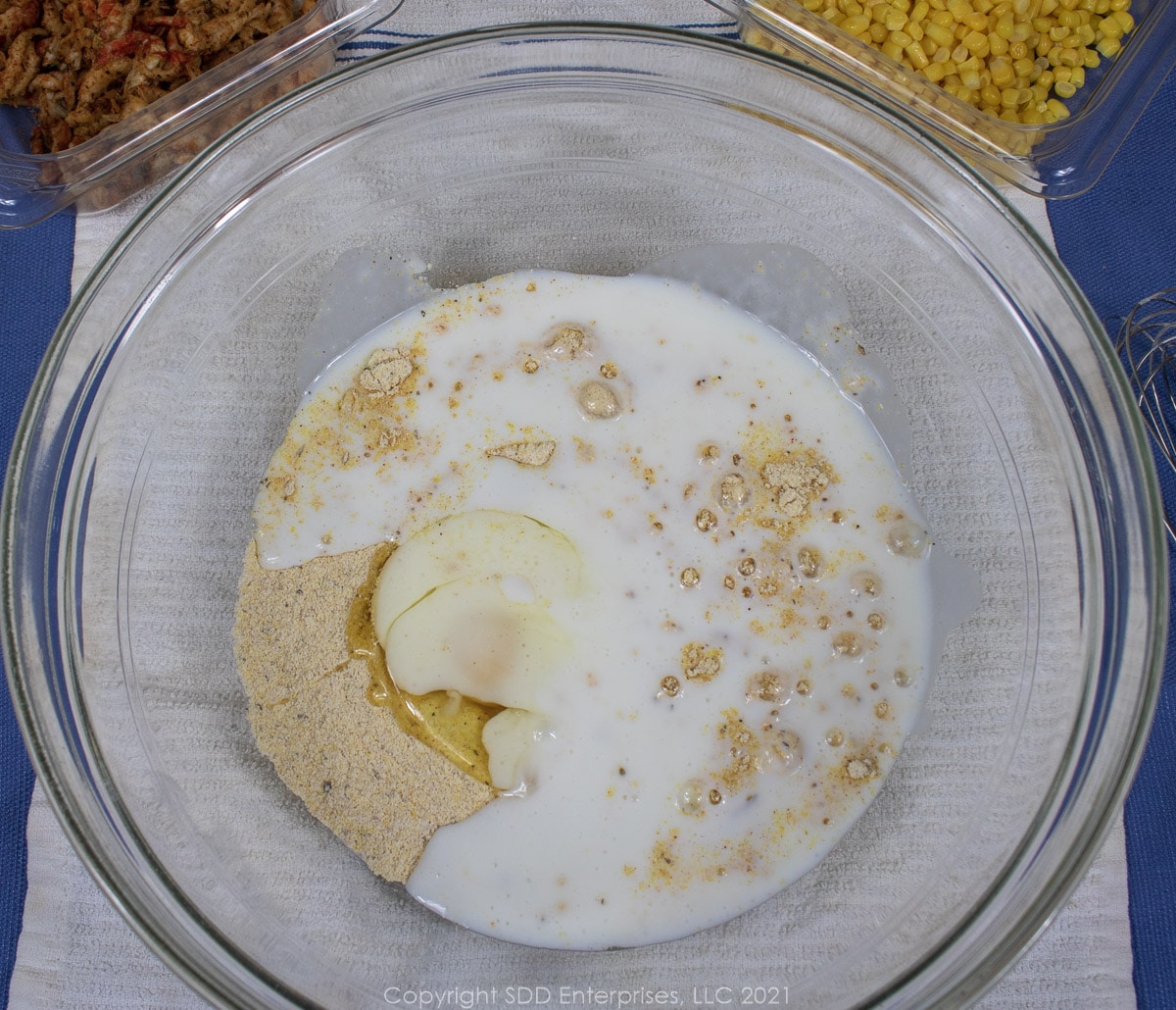 buttermilk added to dry ingredients in a glass bowl