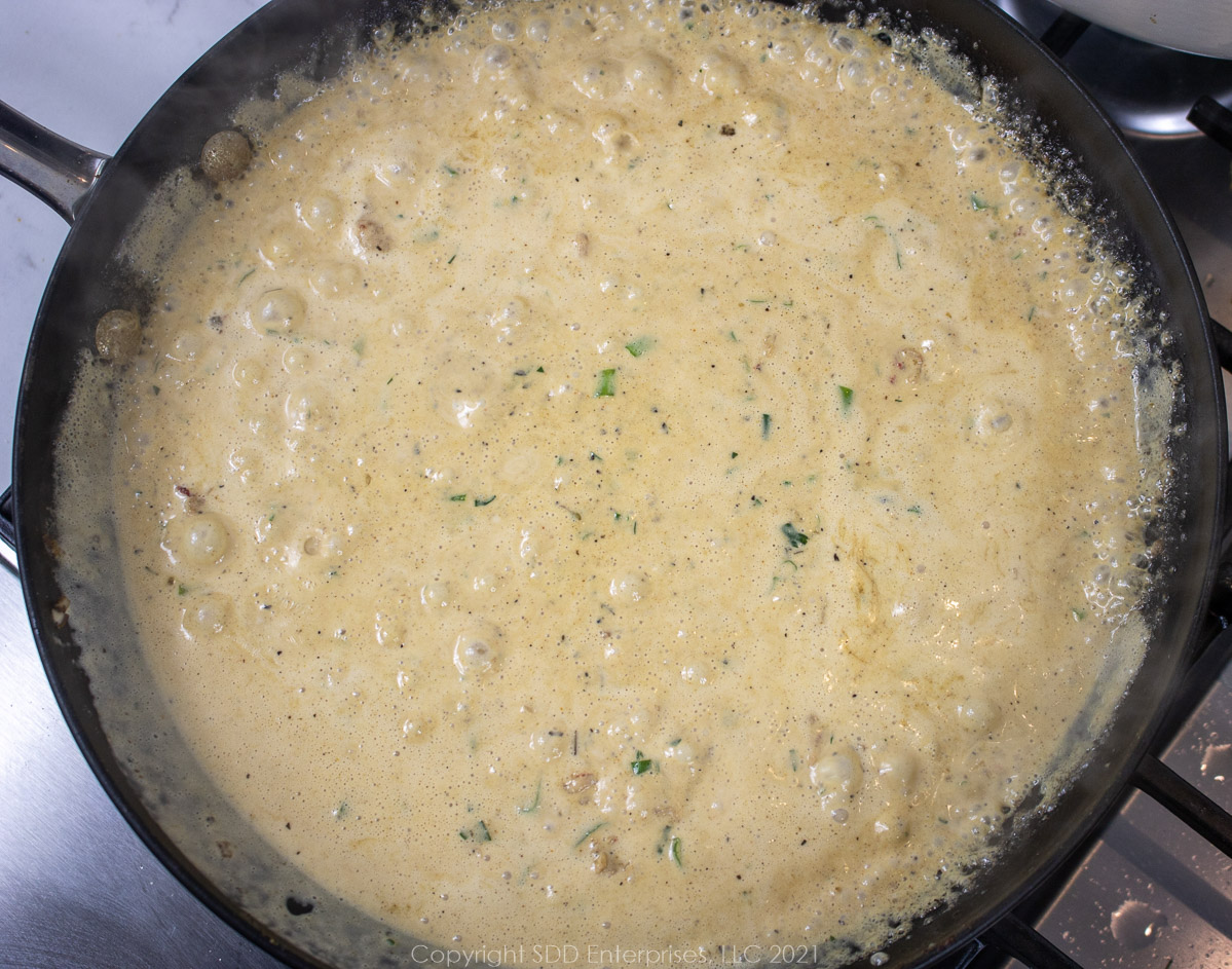 crawfish cream sauce simmering in a frying pan