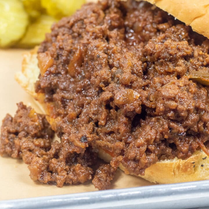 sloppy joes om and onion roll with pickles on the side