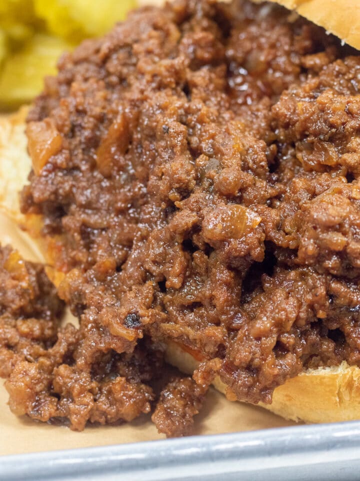 sloppy joes om and onion roll with pickles on the side