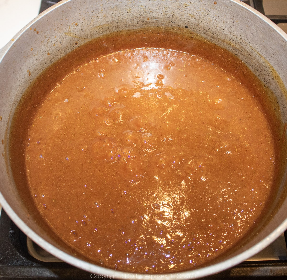 simmering sauce in a small Dutch oven
