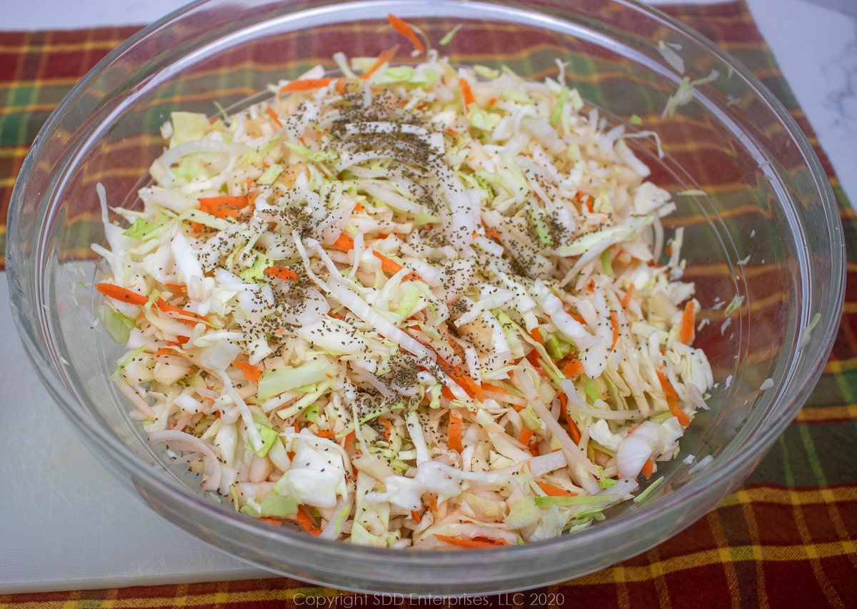 shredded cabbage mixed with apples, onions, carrots and celery seeds