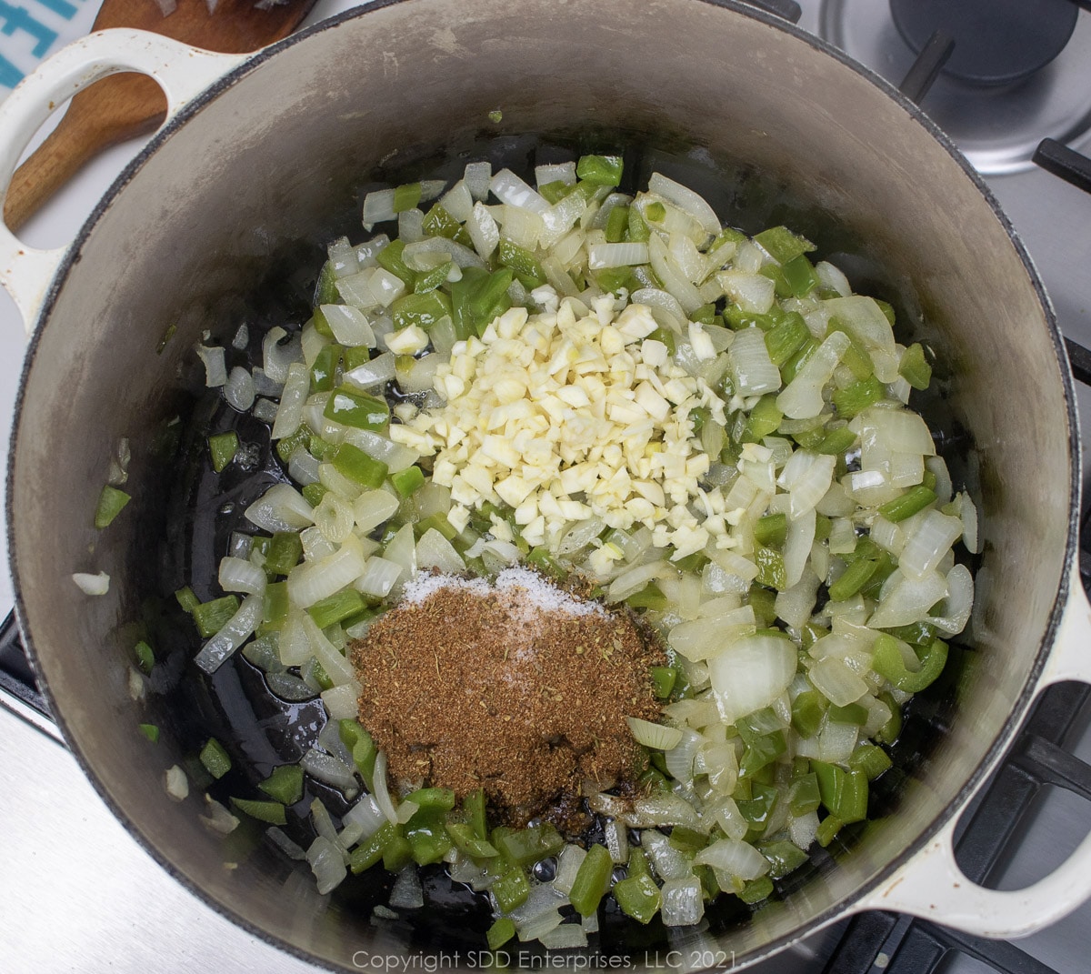 gralic and spices added to sautéing onions in a Dutch oven