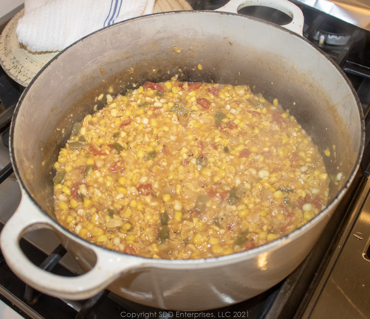 simmering corn and tomatoes in a Dutch oven