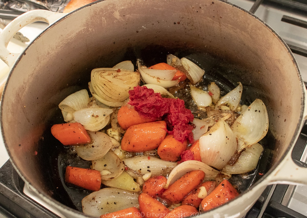 tomato paste with onions and carrots in a Dutch oven