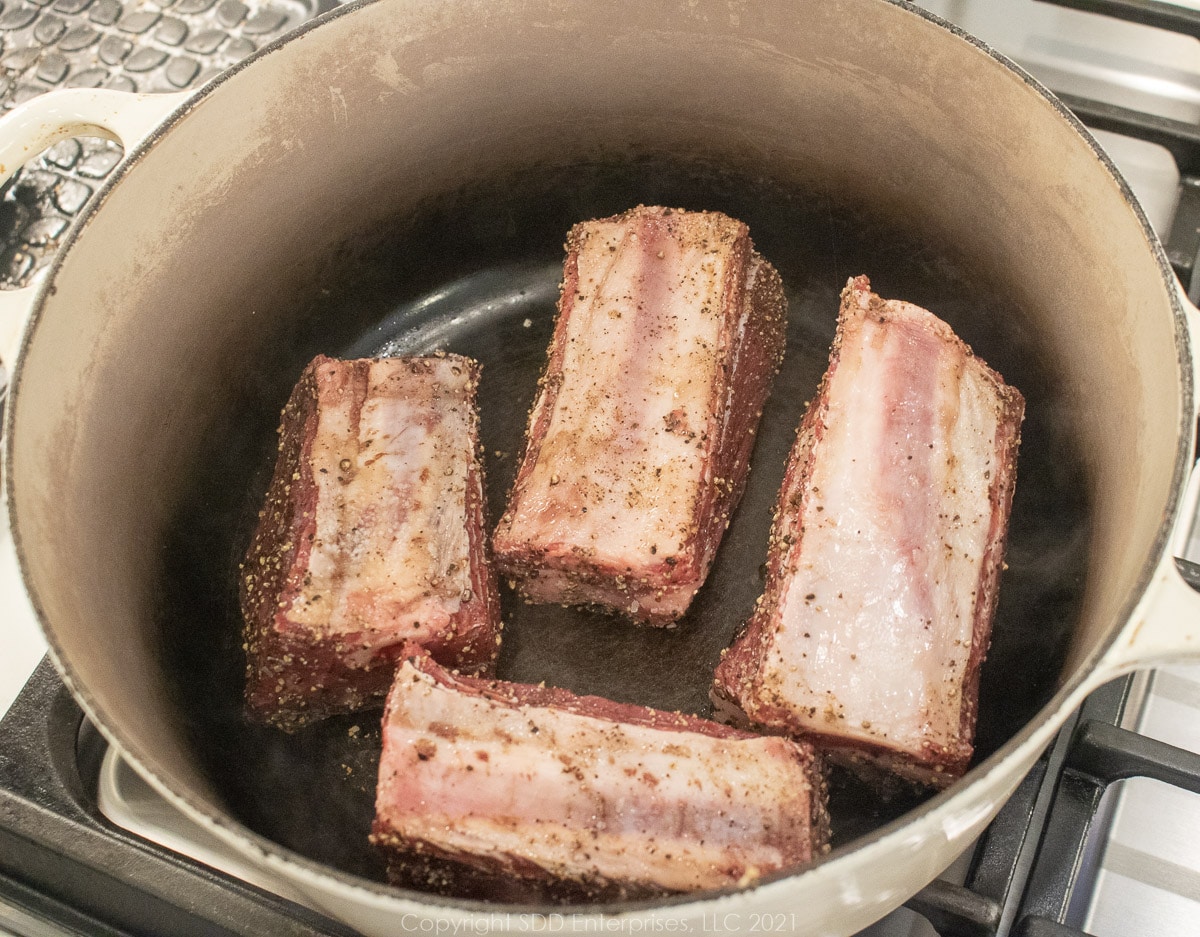 searing beef short ribs in a Dutch oven