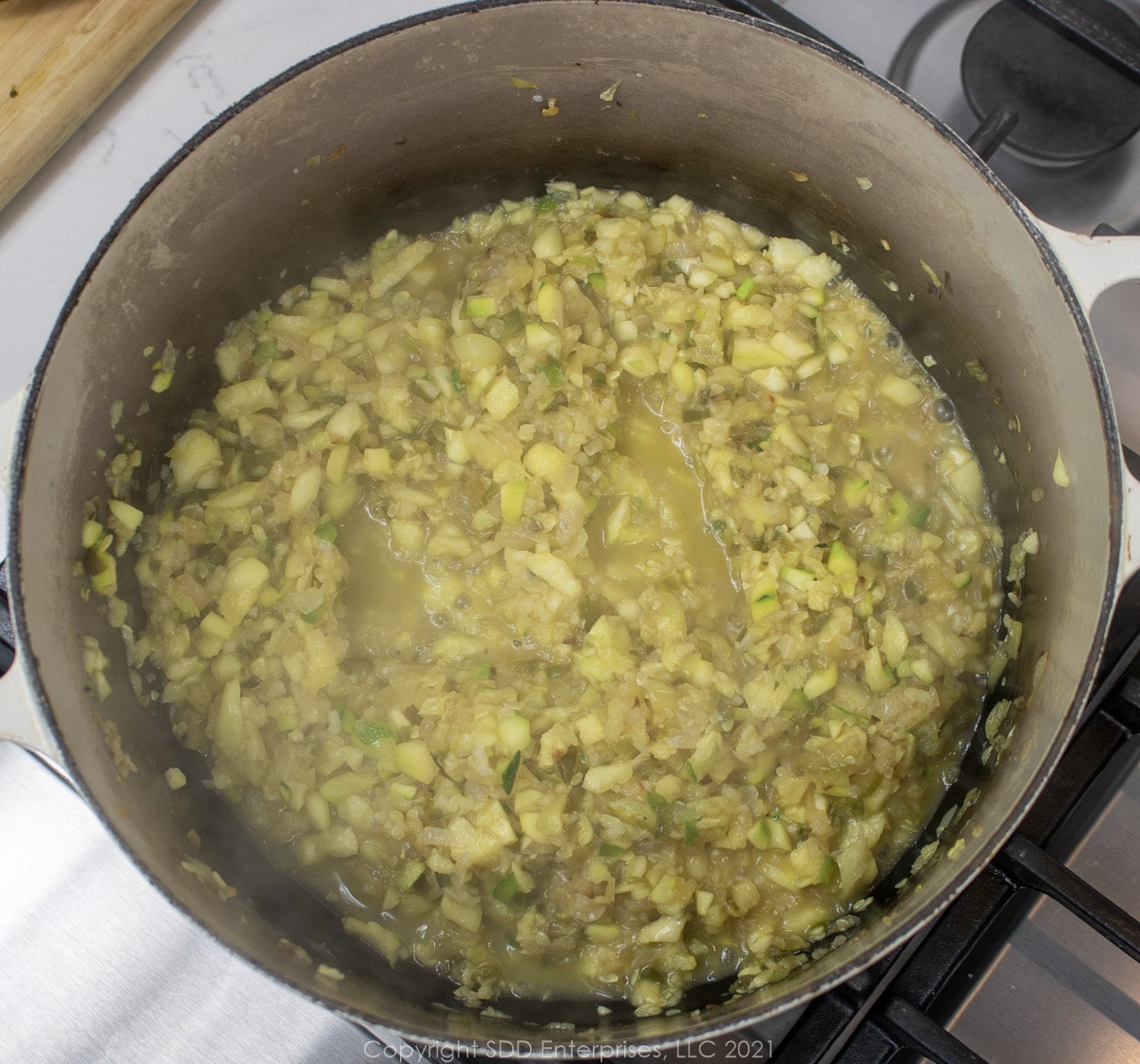 chopped zucchini simmering in a Dutch oven