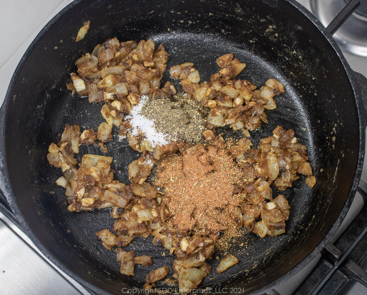 seasonings added to vegetables in a roux in a Dutch oven