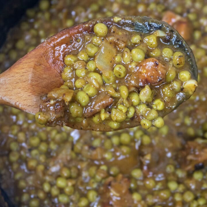peas in a roux in a wooden spoon over a Dutch oven