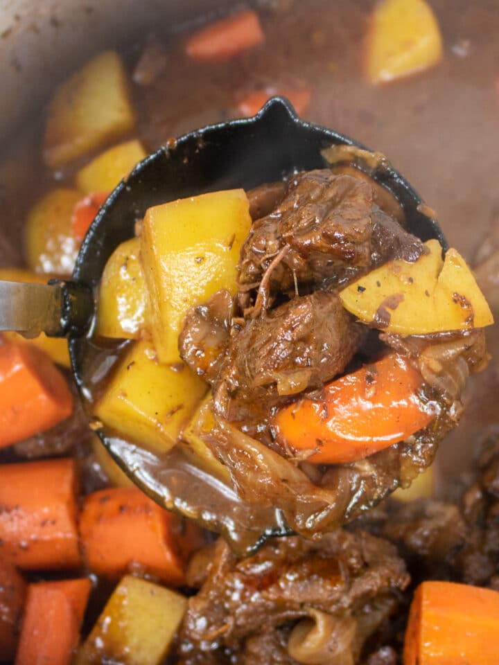 beef stew with potatoes and carrots in a ladle