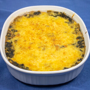 creamed spinach with mushrooms in a white baking dish