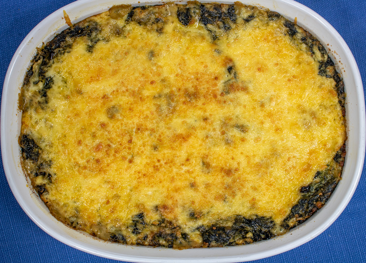 Creamy Spinach and Mushroom Gratin in a white baking dish right out of the oven