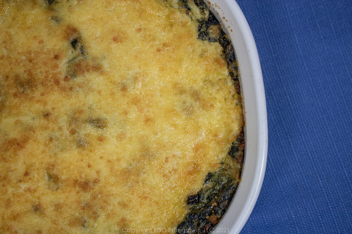 creamed spinach with mushrooms in a white baking dish