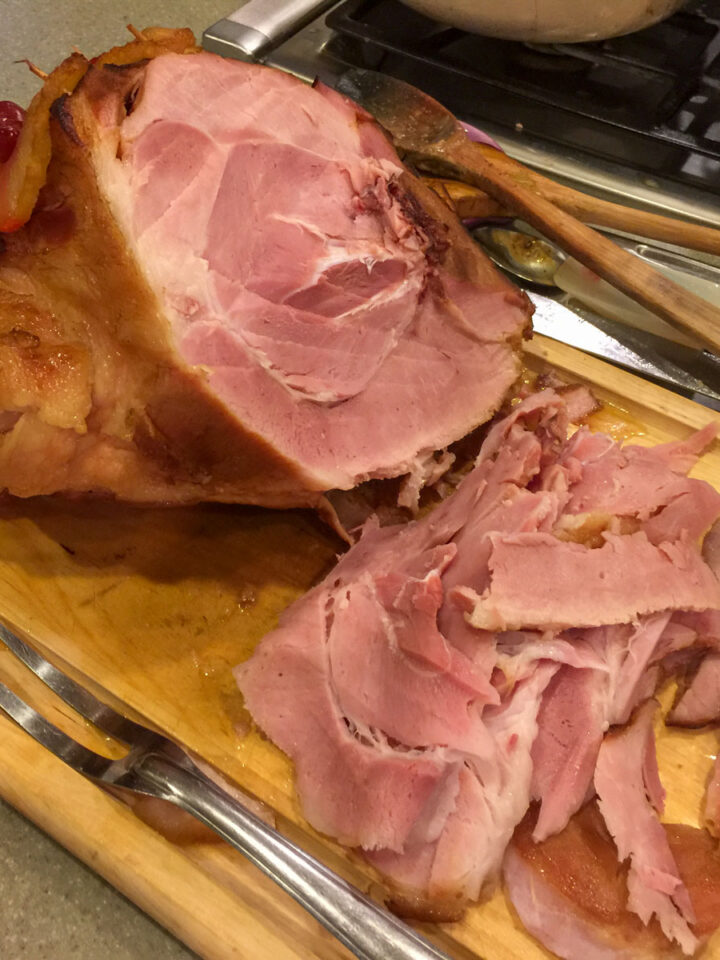 baked ham on a cutting board with a fork