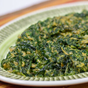 creamed spinach with artichoke on a green platter