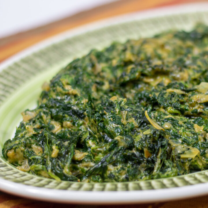 creamed spinach with artichoke on a green platter