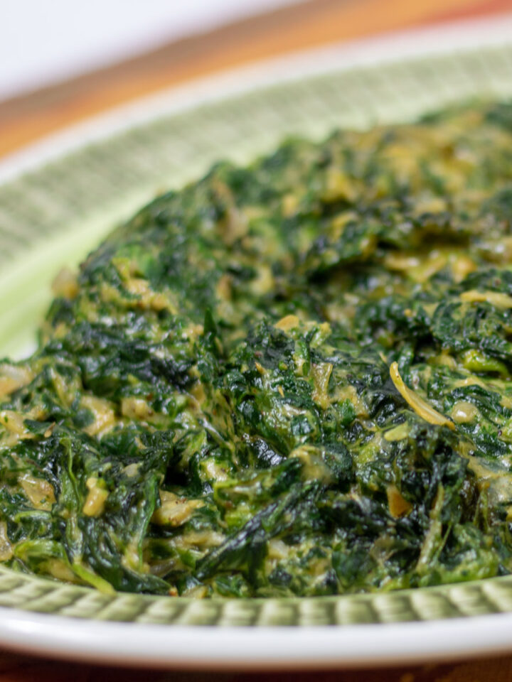 creamed spinach with artichoke on a green platter