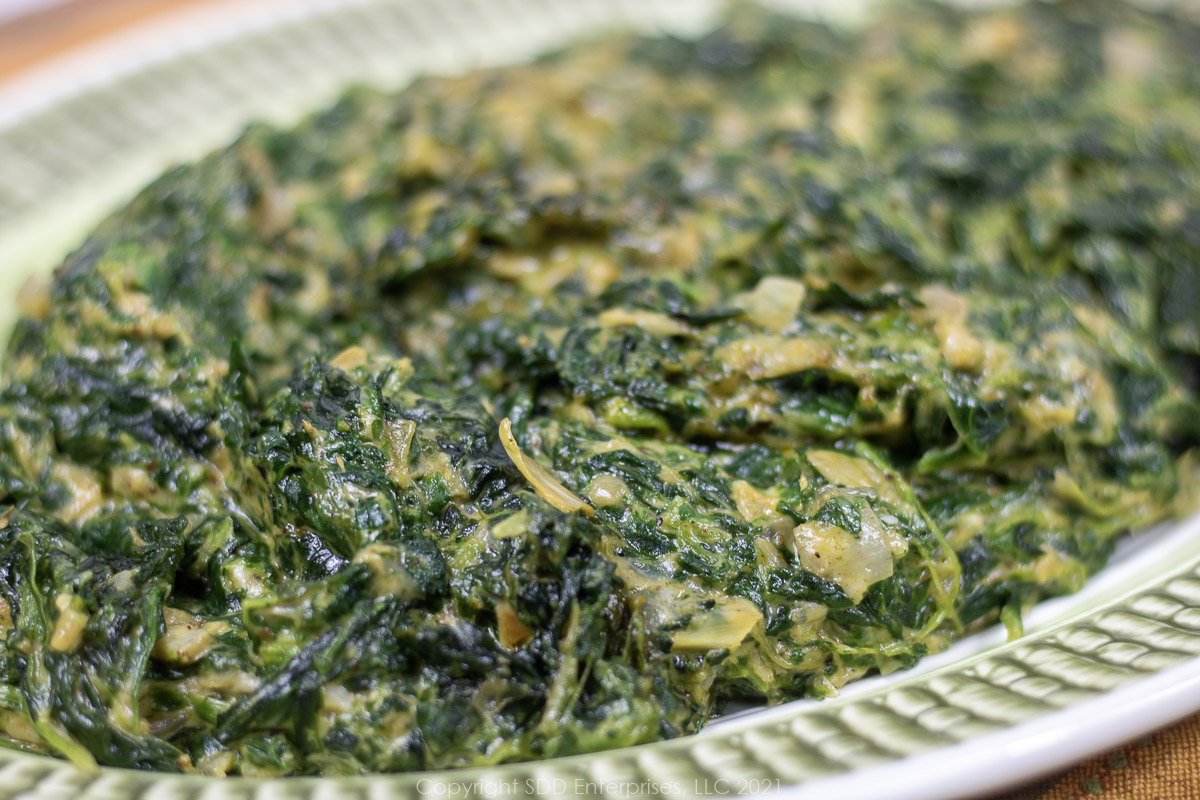 creamed spianch with artichoke on a green platter