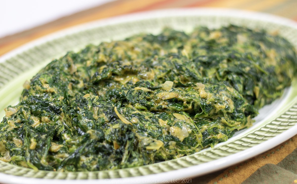 creamed spinach with artichoke on a green platter