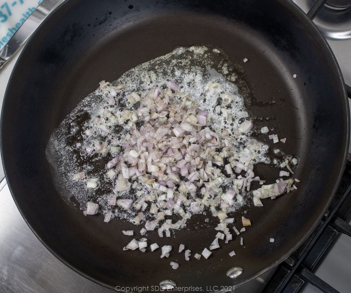 shallots frying in a sauté pan