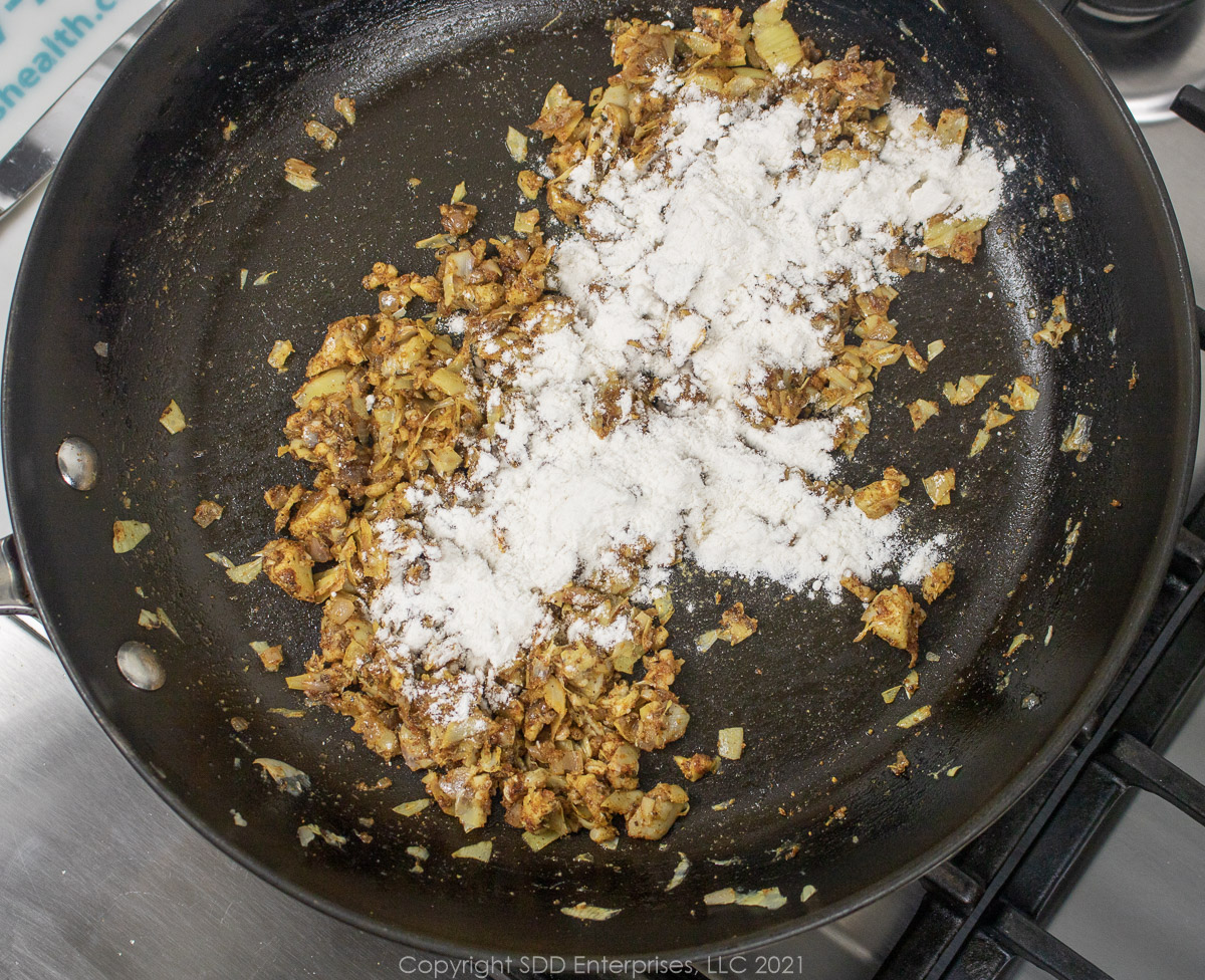 AP flour added to veggies in a sauté pan