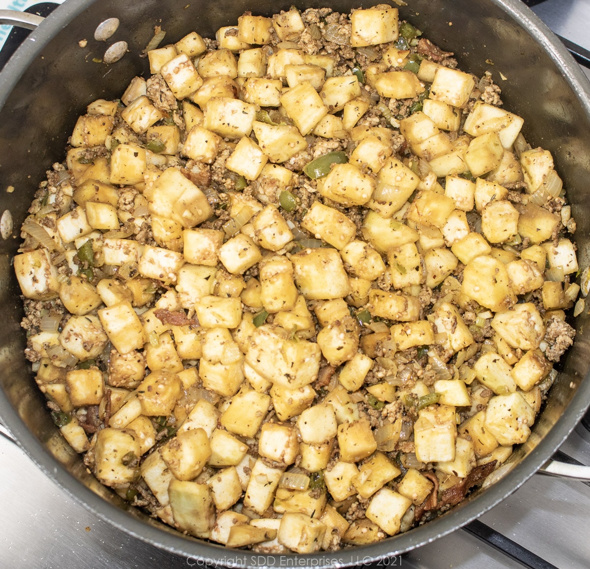 cubed eggplant cooking in vegetables and meat in a Dutch oven