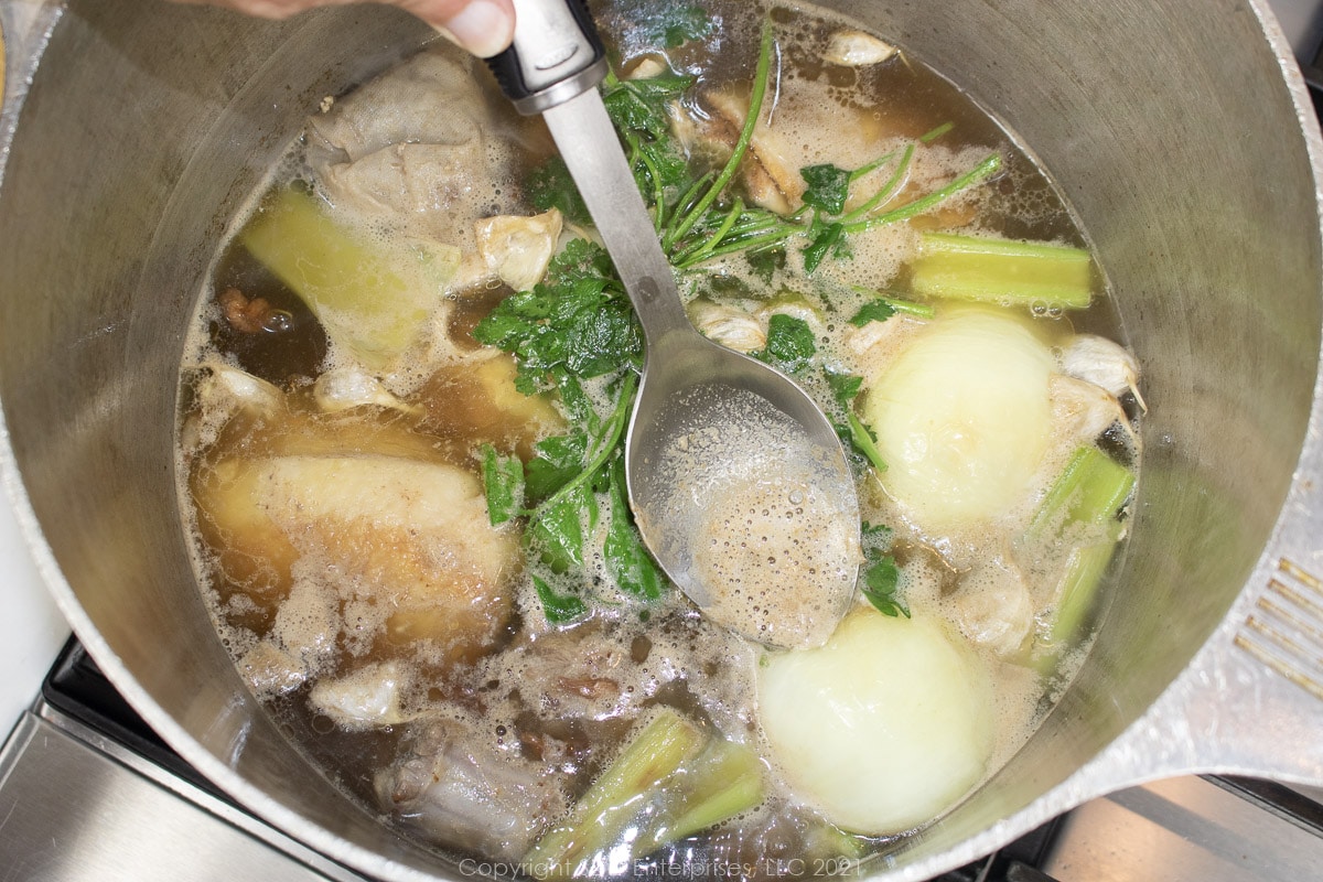 skimming impurities from simmering poultry stock