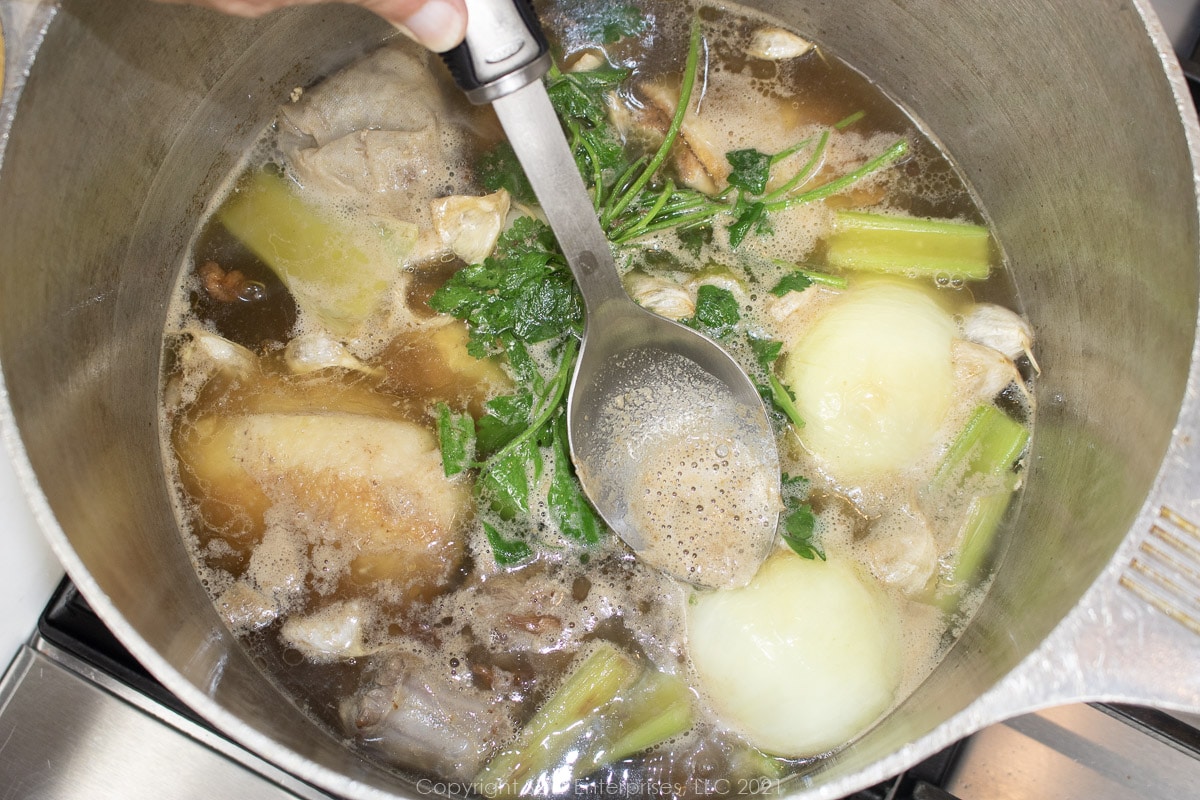 skimming impurities from simmering poultry stock