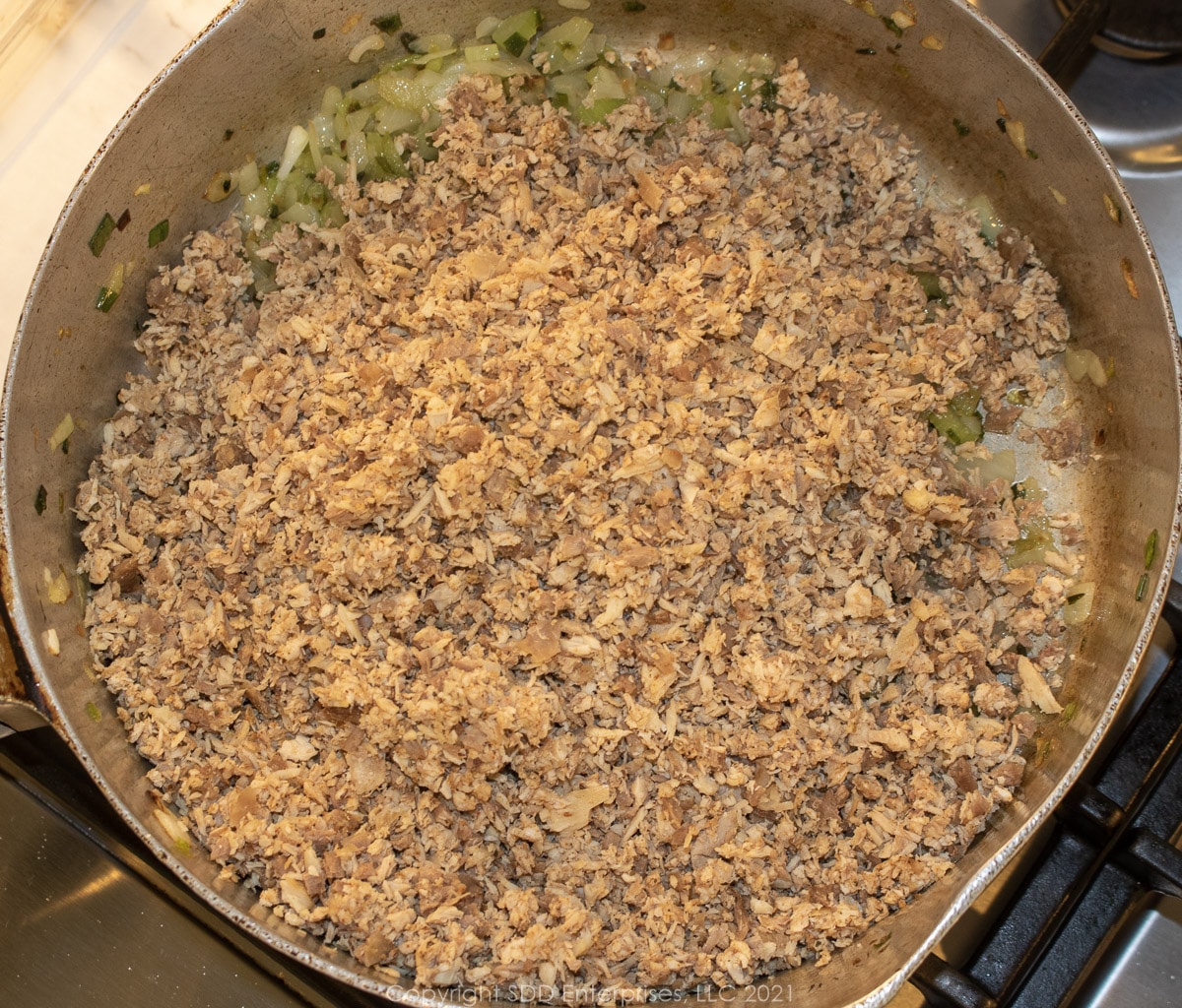 ground poultry meat added to onions in a stock pot
