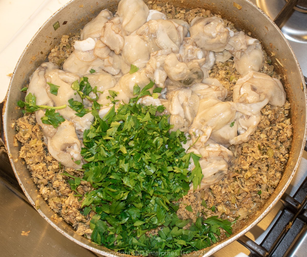 raw oysters and parsley in the stock pot with vegetables 
