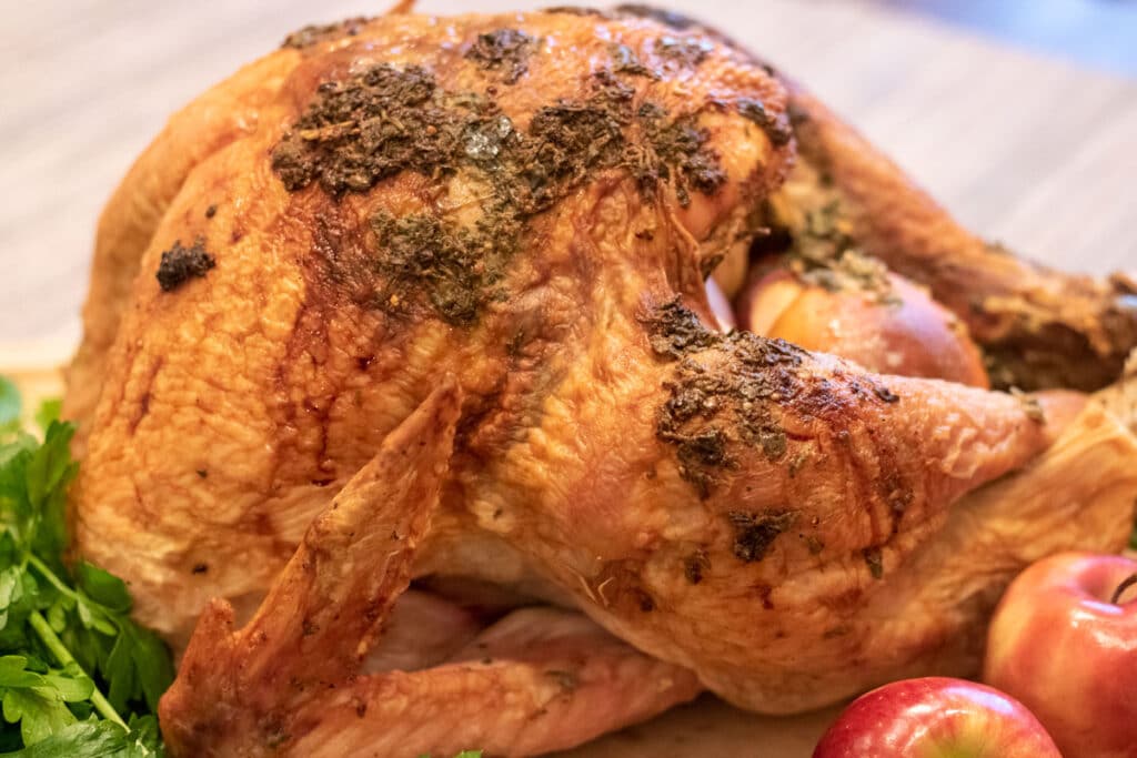 herb roasted turkey with garnishments on a cutting board