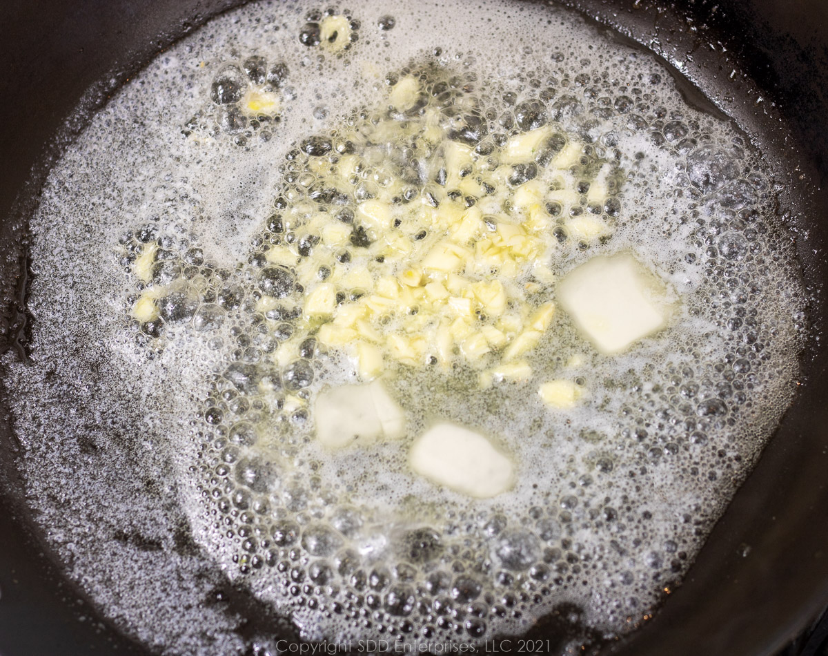 frying garlic in butter in a frying pan