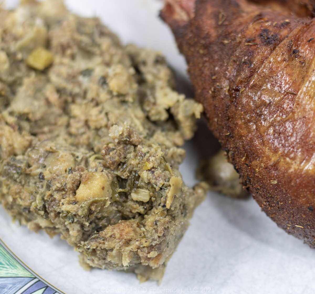 New Orleans oyster dressing on a white plate with a turkey leg