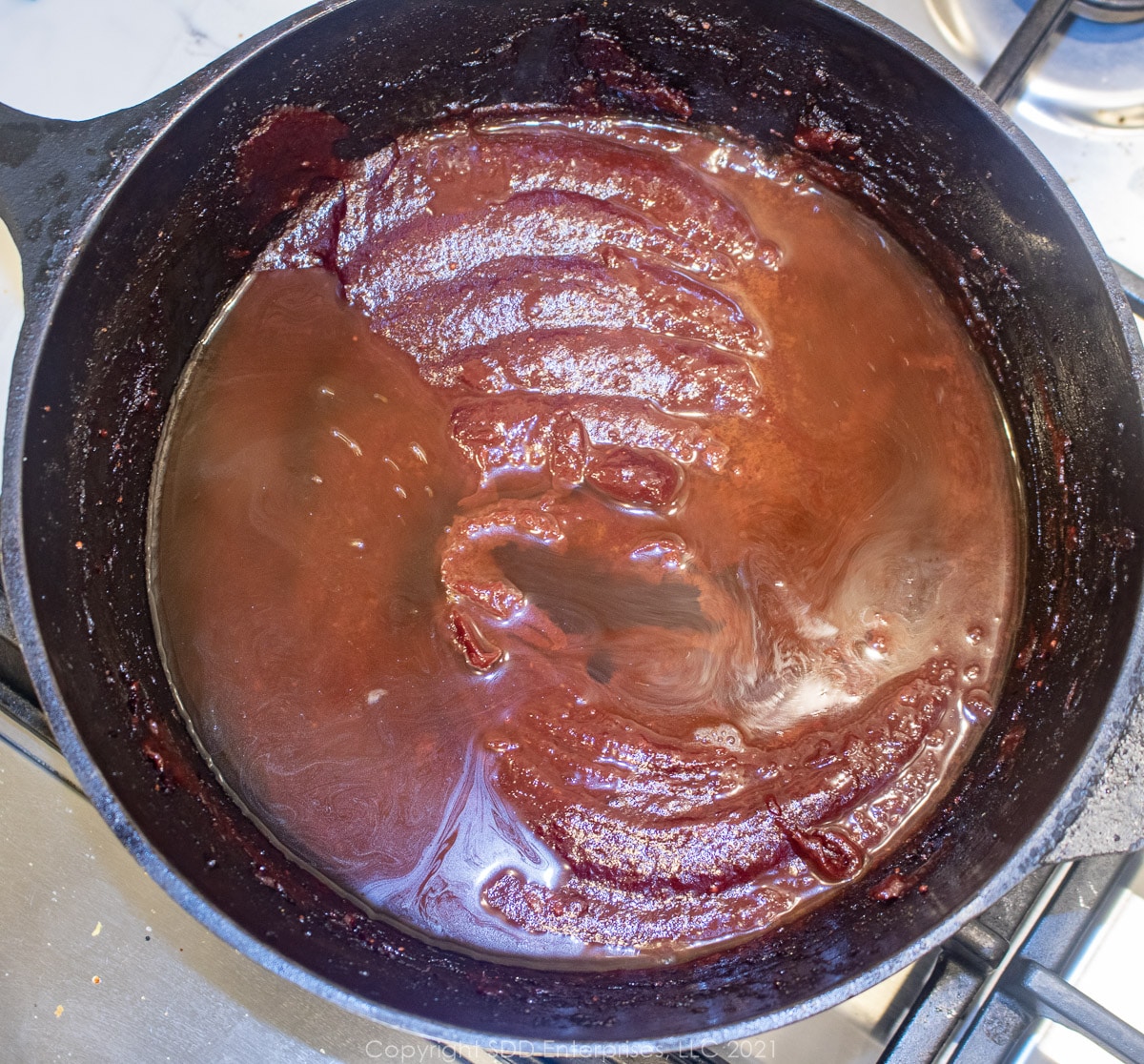 beef stock added to bbq sauce paste in a Dutch oven