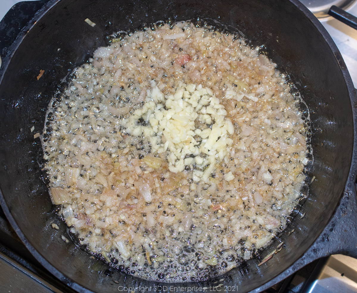 chopped garlic added to onions in a Dutch oven for bbq sauce