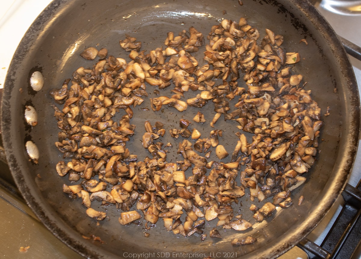 sautéing chopped mushrooms in a sauté pan