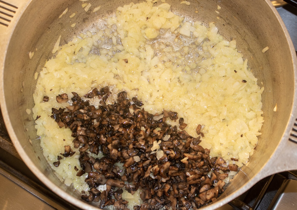 sauteed mushrooms added to the onions in a frying pan