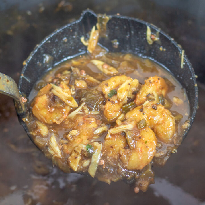 shrimp and okra gumbo in a ladle over a stock pot