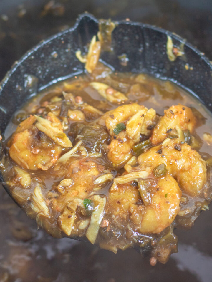 shrimp and okra gumbo in a ladle over a stock pot