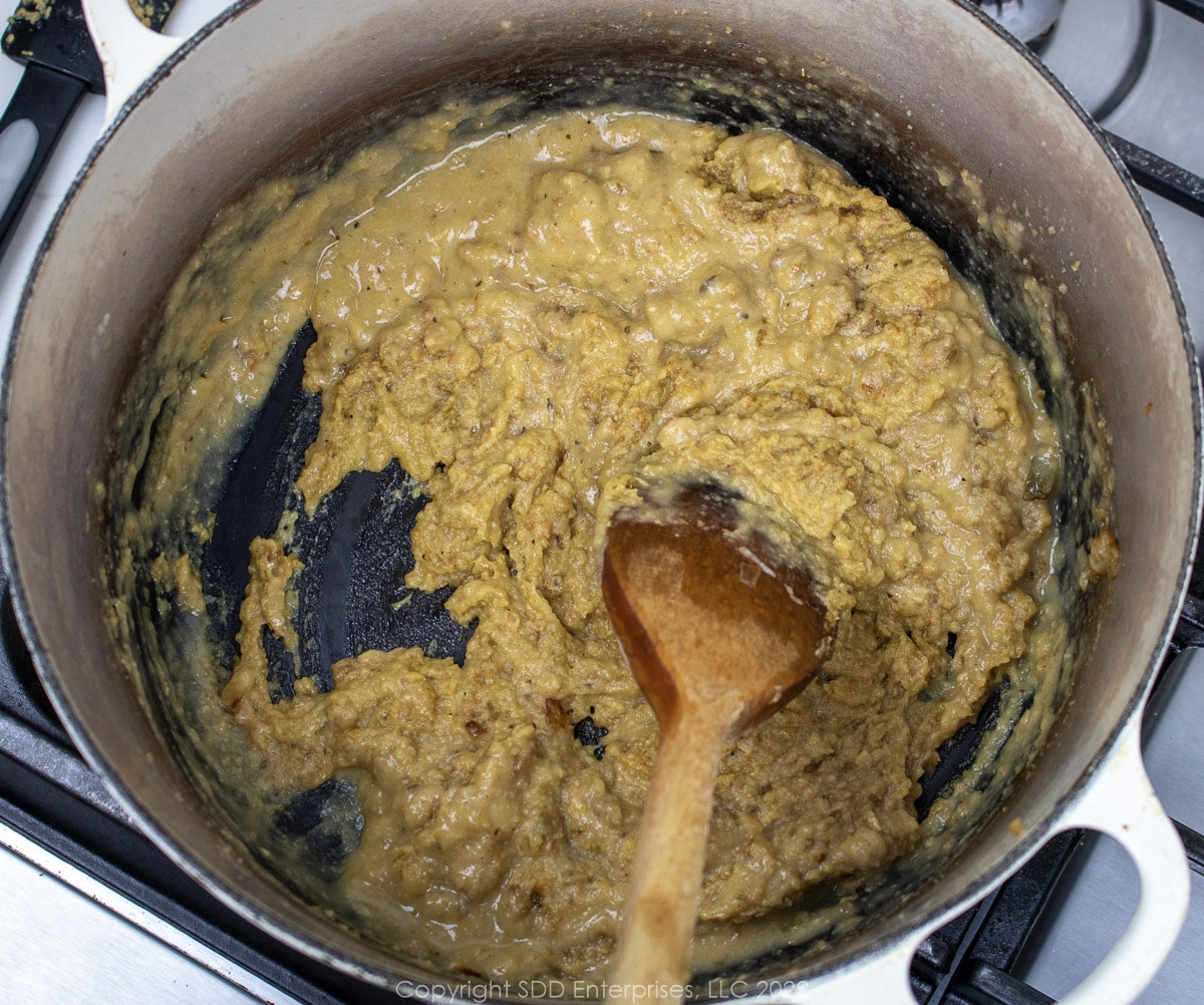 combining stock with purred vegetables and roux in a Dutch oven