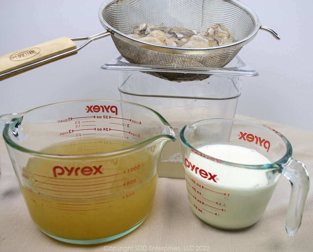 oysters draining with stock and cream in measuring cups