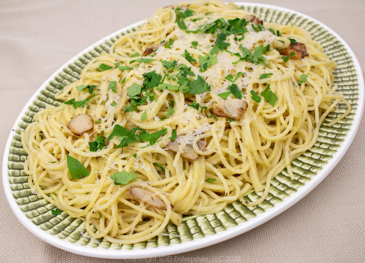 spaghetti Bordelaise with parsley garnish on a green and white platter